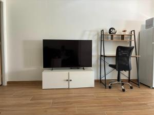 a living room with a television and a chair at NovaStay in Breuillet