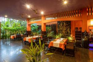 a restaurant with tables and chairs and plants at Golden Butterfly Villa in Siem Reap
