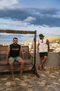 two men sitting on a bench on a roof at Pousada do Trovão - Melhor localização de Arraial in Arraial do Cabo +82 photos