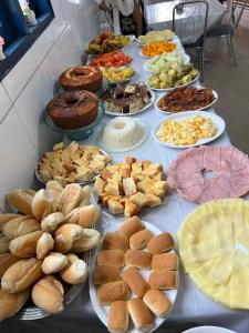 a table full of different types of bread and pastries at Pousada da Cida in Lençóis