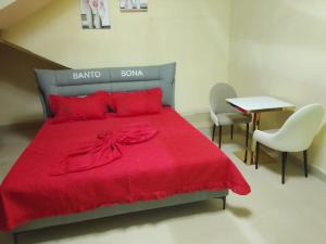 a bedroom with a bed with a red bedspread at Hotel Mardoche Banto in Luanda