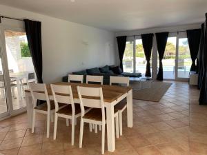 a dining room with a table and chairs and a couch at Casa SONEA private access to Cala nBrut. in Cala en Blanes