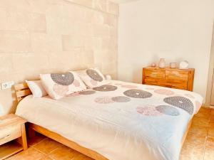 a bedroom with a large bed with pink and gray pillows at Casa SONEA private access to Cala nBrut. in Cala en Blanes +41 photos