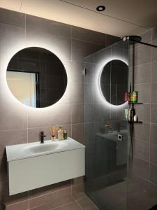 a bathroom with a sink and two mirrors at The Cozy Nook - Modern scandinavisk Studio in Kristianstad