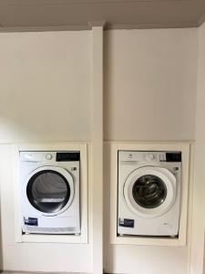 two washing machines are in a white room at The Cozy Nook - Modern scandinavisk Studio in Kristianstad