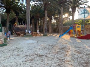 a playground with palm trees and a slide at Casa SONEA private access to Cala nBrut. in Cala en Blanes