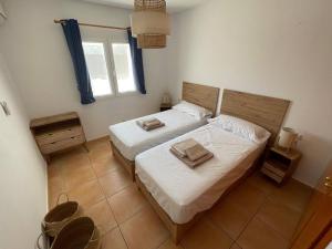 a bedroom with two beds and a window at 6 person house with private pool and garden in Trebeluger +18 photos