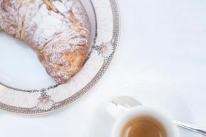 un plato con un trozo de pan y una taza de café en Blu Hotel, en San Nicola Manfredi