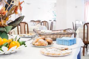 a table with plates of bread and fruit on it at Blu Hotel in San Nicola Manfredi