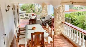 a room with a table and chairs on a balcony at House close to the beach of Punta Prima in Punta Prima