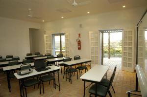 uma sala de aula com mesas e cadeiras numa sala em VOA Mirante Do Café em Santo Antônio do Leite