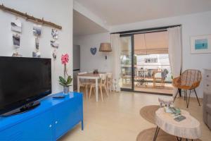 a living room with a blue dresser and a tv at Stunning duplex with two terraces in Cala Blanca in Son Carrio