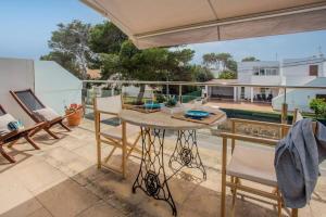a patio with a table and chairs on a balcony at Stunning duplex with two terraces in Cala Blanca in Son Carrio