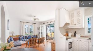 a kitchen and living room with a couch and chairs at Apartment for 6 with a private terrace in Son Bou in Son Bou