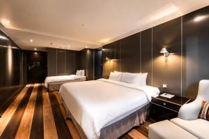 a hotel room with two beds and a couch at Hotel Relax I in Taipei