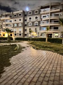 a brick road in front of a large building at Life city home in 6th Of October
