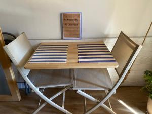 a wooden table and chairs with a napkin on it at la passerelle du couchant in Langlade