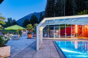 a house with a swimming pool next to a patio at Hotel Vitaler Landauerhof in Schladming