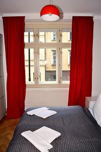 プラハにあるClassic 2BDR suite by Ruterraの赤いカーテンと大きな窓が備わるベッドルーム1室が備わります。