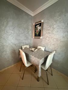 a dining room table with chairs and a painting on the wall at Beautiful appartement in Tétouan
