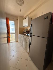 a kitchen with a refrigerator and a tile floor at Beautiful appartement in Tétouan