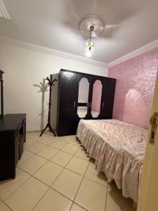 a bedroom with a bed with a pink wall at Beautiful appartement in Tétouan