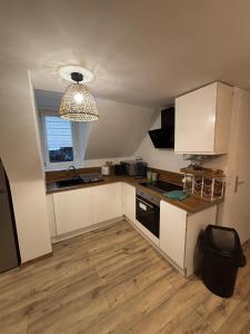 a small kitchen with white cabinets and a window at Le Cocon in Boulogne-sur-Mer +2 photos