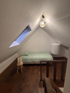 a room with a bed in the attic with a window at Le Cocon in Boulogne-sur-Mer
