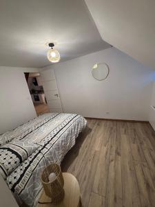 a bedroom with a bed and a wooden floor at Le Cocon in Boulogne-sur-Mer