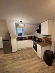 a small kitchen with white cabinets and a window at Le Cocon in Boulogne-sur-Mer
