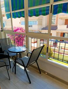 a room with a table and chairs and a window at Apartament La Mata "FELIZ" in La Mata