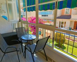 a balcony with two chairs and a table and a window at Apartament La Mata "FELIZ" in La Mata