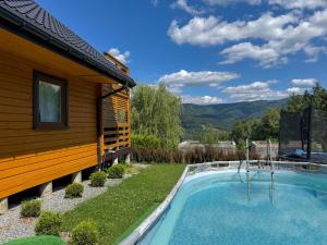 a house with a swimming pool next to a building at Willa Wilk in Międzybrodzie Bialskie