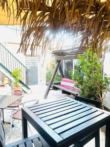 a bench on a patio with a table and chairs at Al Yakhour Hostel in Haifa