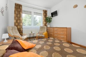 a bedroom with a bed and two chairs and a dresser at Hołcyna 21 in Brenna