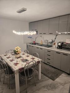a kitchen with a table and chairs and a kitchen with white cabinets at Casa Valor in Lacu Rosu