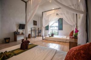 a bedroom with a bed with a canopy at Sabaidee Chiangmai Hotel in Chiang Mai