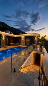 a villa with a swimming pool at night at Vatër by the lake in Shirokë +28 photos