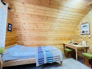 a bedroom with a bed and a wooden wall at Aalam ordo in Shabdan