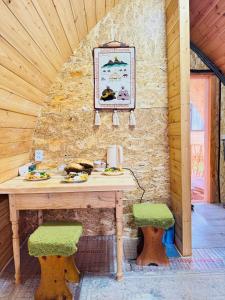 a wooden table with two stools in a room at Aalam ordo in Shabdan