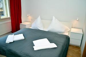 a bedroom with a bed with two white towels on it at Classic 2BDR suite by Ruterra in Prague