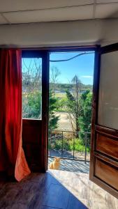 a cat sitting in a room looking out a glass door at Casa Petricor in Río Tercero