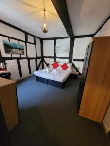 a room with a bed with red pillows in it at The Bugle Hotel in Titchfield