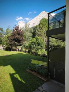 a house with a view of a park with mountains at Orchidea Suite & SPA Apartments in Canazei