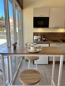 a kitchen with a wooden table and a counter top at Le Studio Côté Cour in Oberbetschdorf +6 photos
