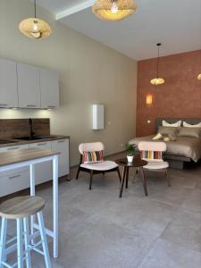 a kitchen and living room with a bed and chairs at Le Studio Côté Cour in Oberbetschdorf