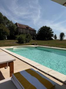 a large swimming pool in front of a house at Domaine de Chaunac in Chaunac