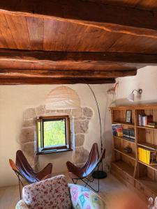 a living room with chairs and a stone fireplace at Refugio Ivanini in Zagorje