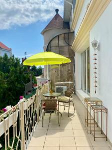 a patio with a table and chairs and a yellow umbrella at Parasolka in Odesa
