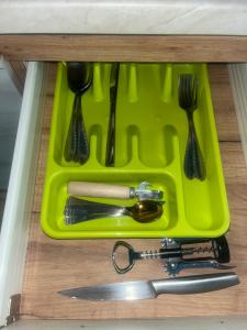 a green tray with utensils in a drawer at Shark in Liepāja